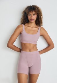 Set di reggiseno e pantaloni corti rosa chiaro senza cuciture, realizzato in tessuto morbido e elastico, con una fascia larga in vita e un design con scollo a barchetta.