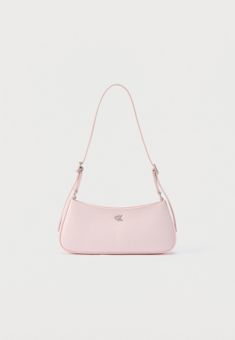 Μικρή ροζ ώμου τσάντα σε παστέλ απόχρωση με λεπτό λουράκι και ασημί λογότυπο "CK" στο κέντρο πάνω σε μονόχρωμο φόντο.
