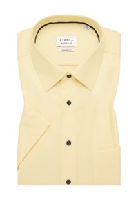 Camicia gialla a maniche corte con un sottile motivo a quadretti, colletto con bottoni, bottoni neri e taschino sul lato sinistro del petto. Design a vestibilità comoda.
