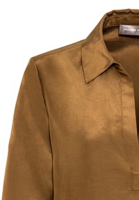 Krage och övre del av en brun satinblus med minimalistisk design och mjuk lyster. Etikett synlig inuti kragen.