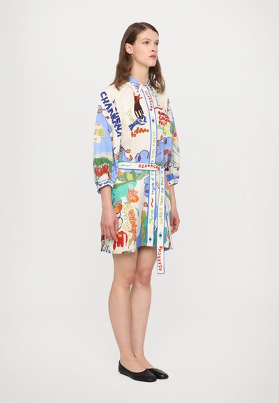 Spalvoti, raštuoti suknelė su didelėmis grafinėmis figūromis. Turi ilgas rankoves, prigludusią liemenį ir derančią juostą. Audinys atrodo lengvas.