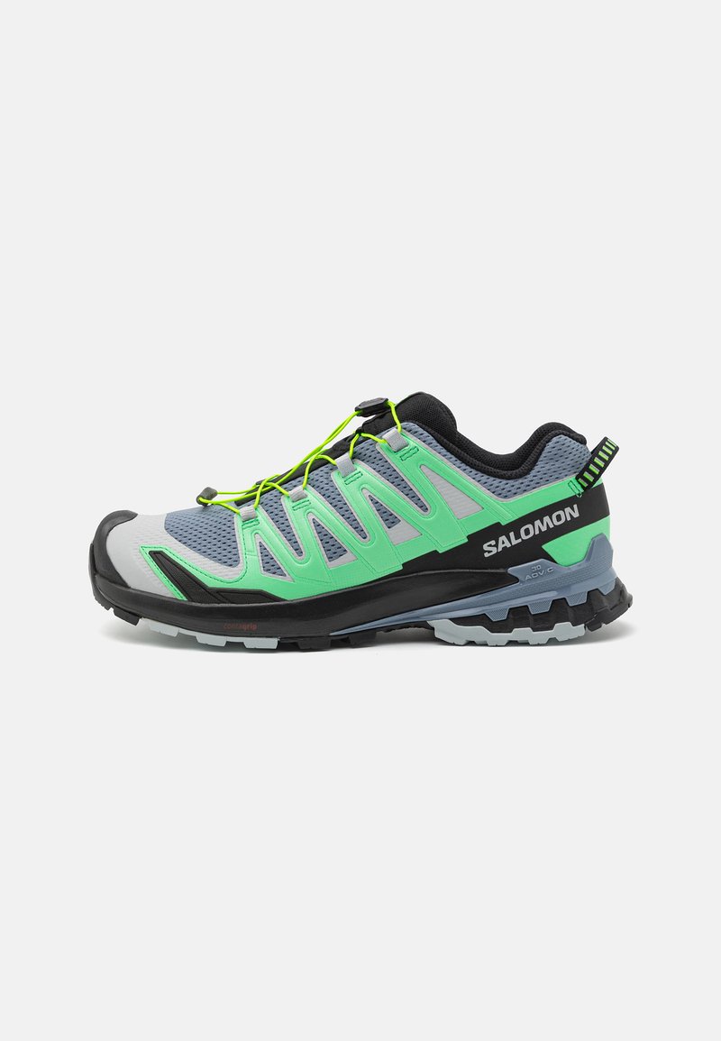 Salomon trail løbesko med en grå mesh-overdel med grønne detaljer, sort hæl og snøresystem. Tekstureret gummisål for bedre greb.