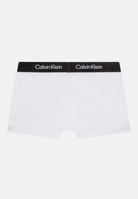 Calvin Klein witte boxershorts met een zwarte elastische tailleband met witte logotekst. Zacht katoenen materiaal, aansluitend ontwerp, gladde textuur.