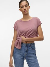Lichtroze kortemouwen shirt met een losse pasvorm, gecombineerd met hooglopende blauwe spijkerbroeken. Glad textuur en eenvoudig ontwerp.