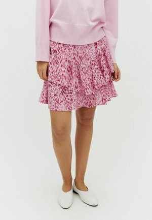 Ružová vrstvená sukňa s volánikovým dizajnom a kvetinovým vzorom. Kombinovaná s svetloružovým svetríkom a bielymi balerínami.