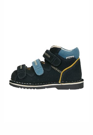 Children’s black and blue suede orthopedic shoe with yellow accent, two Velcro straps, and white stitched sole, side view on white background.