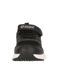Sneaker nera con parte superiore in rete, chiusura con lacci e velcro, suola bianca, texture a zigzag sui lati e un logo sulla cinghia.