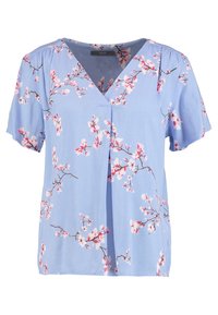 Blusa floral de color azul claro con mangas cortas, escote en V y abertura frontal. La tela es suave y presenta un patrón de flores en rosa y blanco.