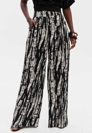 Weite Hosen in Schwarz und Creme mit einem strukturierten abstrakten Muster. Taillierter Bund mit Seitentaschen, der eine lockere Passform bietet.