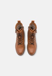 Bottines en cuir marron avec un design à lacets, fermeture éclair sur le côté et tirant à l'arrière. Texture lisse avec bout arrondi et semelle durable.