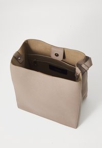 Sac à main en cuir beige avec un extérieur texturé, un haut ouvert, une poche zippée intérieure et deux attaches de sangle ; forme rectangulaire élégante.