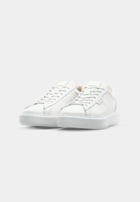 White leather sneakers with a smooth finish, lace-up closure, rounded toe, and textured rubber sole. Minimalistic design with subtle accents.