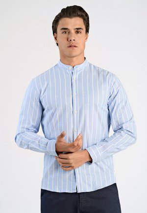 Camisa azul claro de botones con rayas verticales blancas, cuello mandarín y mangas largas. La tela parece suave y texturizada.