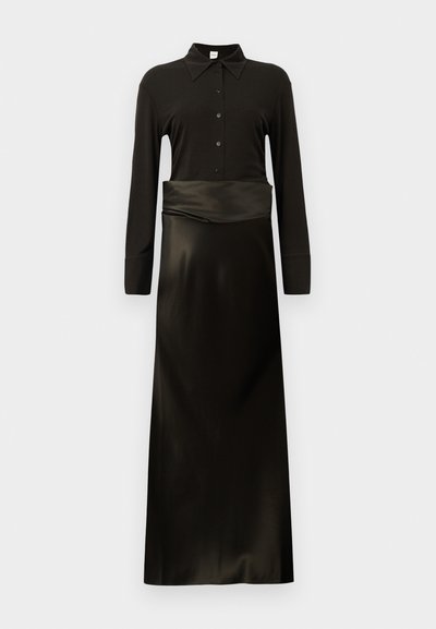 Fekete, hosszú ujjú ruha, gallérral, gombos záródással és selymes, lágyan omló szoknyával. Sima textúra, testhez simuló ruhatest.