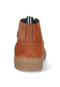 Brown leather ankle boots with textured surface, contrasting cream rubber sole, and striped pull tab. Features embossed brand logo on heel.