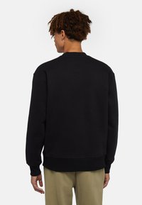 Zwarte sweatshirt met ronde hals, lange mouwen en geribbelde boorden. Zachte textuur, comfortabele pasvorm en geen zichtbare logo's of patronen.