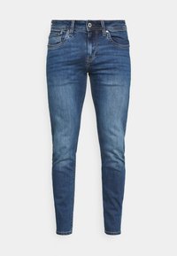 Skinny jeans in dark blue denim, featuring a mid-rise waist, five pockets, and subtle faded detailing on the thighs and knees.