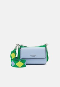 Piccola borsa a tracolla rettangolare in pelle azzurro chiaro con patta frontale e logo argento, abbinata a una tracolla in tessuto verde con diamanti blu e gialli.
