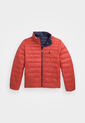 Veste matelassée rouge avec fermeture éclair et col intérieur bleu marine. Présente un motif matelassé vertical et un petit logo sur le côté gauche de la poitrine.