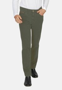 Oliwkowe bawełniane spodnie z prostymi nogawkami, z przednimi kieszeniami i detalem w postaci kieszeni na zamek. Na nogach czarne botki za kostkę.