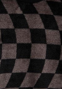 Tela de lana de cuadros en negro y gris con una superficie suave y texturizada. Los patrones en forma de diamante crean un bold contraste en color y diseño.