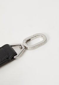 Cinturino in pelle nera con chiusura in metallo argentato. La chiusura presenta il nome del marchio inciso "KARL LAGERFELD" e un design elegante e arrotondato.