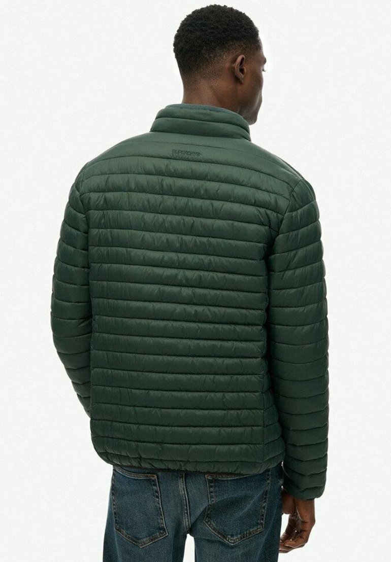 Pikowana kurtka w ciemnozielonym kolorze, z kołnierzem stojącym. Materiał wydaje się gładki z delikatnym połyskiem.