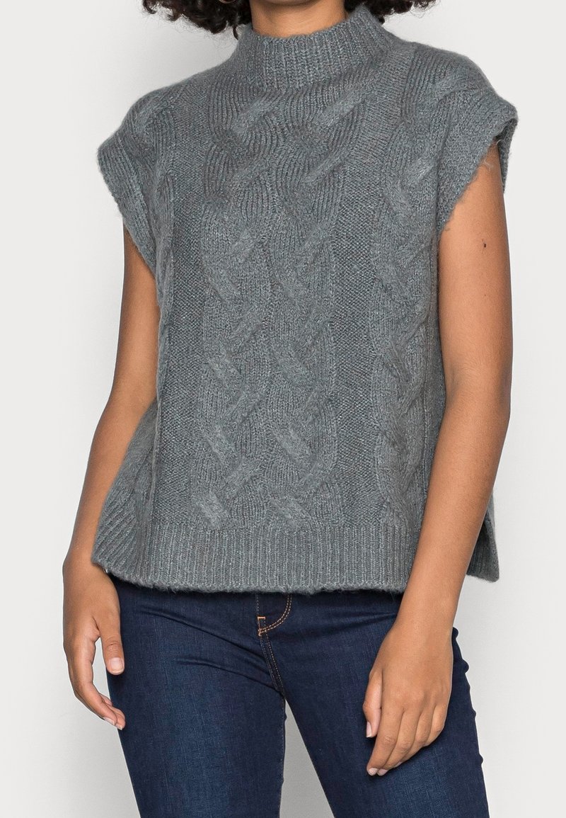 Valokauluksellinen, lyhythihainen pusero vaaleanharmaana, jossa on letitetty neulekuvio ja resorit helmassa. Pehmeä, teksturoitu lanka hienostuneilla yksityiskohdilla.