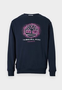 Sweatshirt bleu marin cu logo-ul pomului Timberland în roz și alb și textul "Established 1973" pe față, mâneci lungi, cu manșete și tiv ondulat.