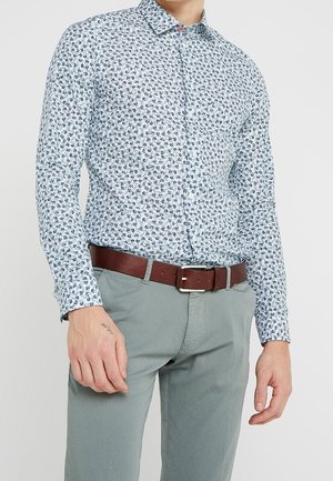Himmelblaues Hemd mit floralem Muster, langen Ärmeln und Kragen. Kombiniert mit grauen Hosen und einem braunen Ledergürtel.