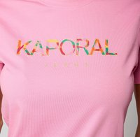 T-shirt en coton rose avec un logo « KAPORAL » multicolore imprimé et un texte « JEANS » plus petit en dessous. Encolure simple et ronde.
