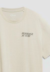 T-shirt beige maniche corte con scollo tondo e testo nero "HOMMAGE AU SURF" sul petto sinistro, realizzato da s.Oliver nella taglia 22L.