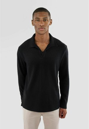 Svart långärmad polo-tröja med en texturerad ribbad design, med pointed krage och avslappnad passform.