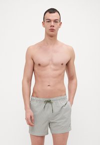 Costumi da bagno a righe in verde chiaro e bianco, con vita elasticizzata, chiusura con cordino e tasche laterali.
