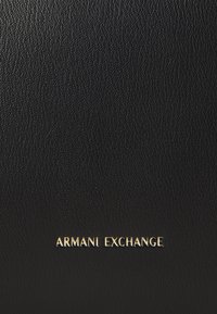 Portefeuille en cuir noir avec une surface texturée et un logo "ARMANI EXCHANGE" en relief doré. Design compact et minimal sans embellissements supplémentaires.