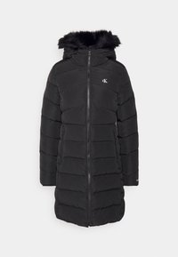 Abrigo negro acolchado con capucha de pelo sintético, cremallera frontal, bolsillos laterales y diseño acolchado. Con detalle de logotipo en el pecho.