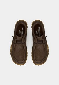 Zapatos de cuero marrón con punta redondeada, suela de goma color tostado y un diseño simple. Cuenta con un sistema de cordones y una plantilla acolchada.