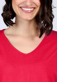 Rotes V-Ausschnitt-Oberteil mit kurzen Ärmeln, aus weichem Stoff. Verfügt über einen schlichten Ausschnitt und eine glatte Textur, mit einem dezenten Glanz.