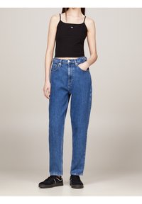 Czarny krótki top na ramiączkach, jeansy z wysokim stanem w niebieskim kolorze o luźnym kroju, z pięcioma kieszeniami, widocznymi szwami i zapinane na guzik.