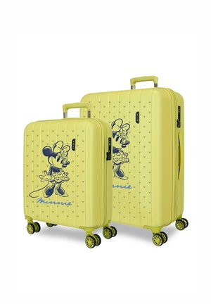 Dos maletas rígidas amarillas con ruedas negras presentan un gráfico azul de Minnie Mouse y un asa, mostradas en tamaños pequeño y grande.