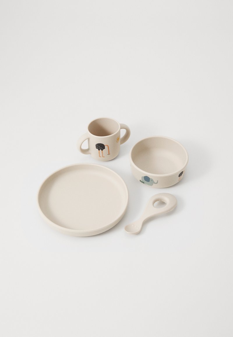 Ensemble de vaisselle pour enfants en beige doux. Comprend une assiette, un bol, une tasse avec anses et une cuillère. Présente des motifs d'animaux : autruche, éléphant.