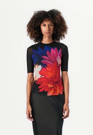 Top à manches courtes en noir avec un design floral vif comportant des fleurs rouges, roses, bleues et blanches. Tissu lisse avec une silhouette ajustée.
