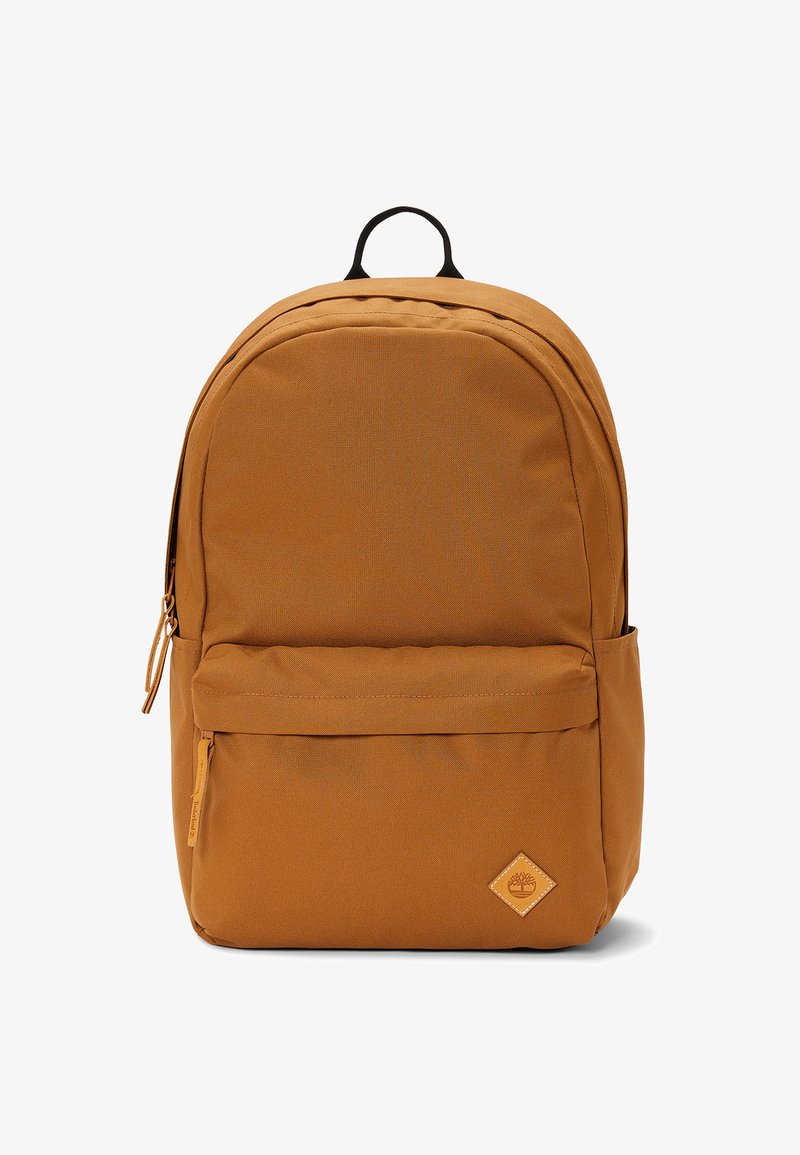 Zaino di tessuto marrone con forma arrotondata, tasca frontale con zip, tasca laterale e un'etichetta con logo. Include una maniglia superiore e spallacci regolabili.