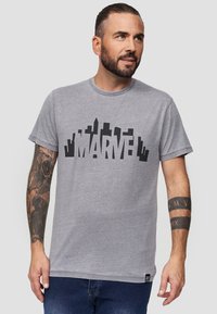 Šedé bavlněné tričko s krátkými rukávy, které zdobí odvážná černá grafika "MARVEL". Rovný spodní lem a design s kulatým výstřihem.