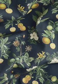Bloemrijke stof met gele en groene citrusvruchten en witte bloemen op een donkerblauwe achtergrond, met bladdetails en een gladde textuur.
