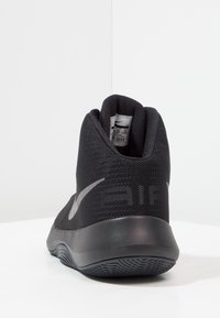 Czarne buty sportowe z siateczkową cholewką, zaokrąglonym obcasem i teksturowaną gumową podeszwą. Posiadają srebrne logo marki na boku oraz wsparcie w okolicy kostki.