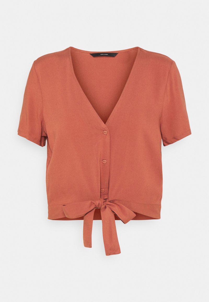 Blouse à manches courtes de couleur rouille avec un col en V, une fermeture à boutons sur le devant et un détail noué à la taille. Texture lisse, design décontracté.