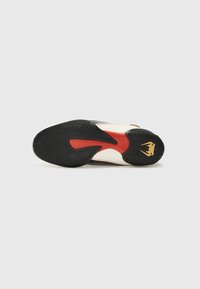 Soletta in gomma nera e crema con motivo strutturato, dettagli rossi nella suola intermedia e un logo dorato sul tallone.