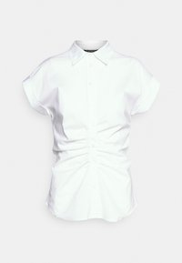 Valkoinen lyhythihainen paita kauluksella, jossa on rypytetty yksityiskohta edessä ja nappilista. Pehmeä puuvillakangas.