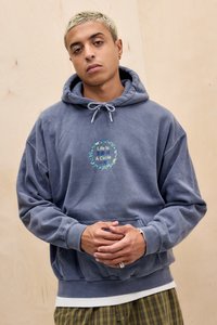 Felpa blu, oversize, in tessuto morbido con tasca frontale. Presenta un design circolare ricamato con testo, cappuccio con cordoncino e polsini a coste.